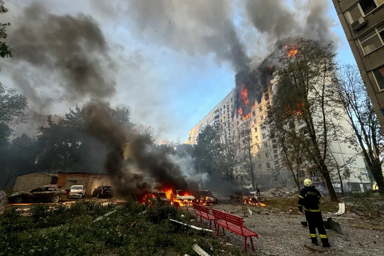 A firefighter looks at an apartment building and cars which burn after a Russian air strike amid Russia's attack on Ukraine in Kharkiv on Friday.