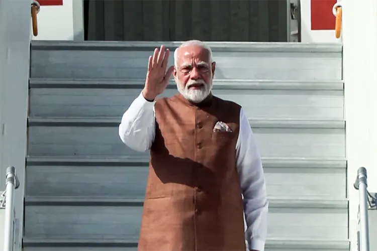 Prime Minister Narendra Modi waves as he emplanes for Saudi Arabia, in New Delhi on Tuesday. 