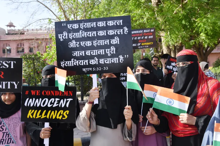 Women hold placards and National Flags during a protest against the Pahalgam Terror Attack in Bikaner on Thursday.