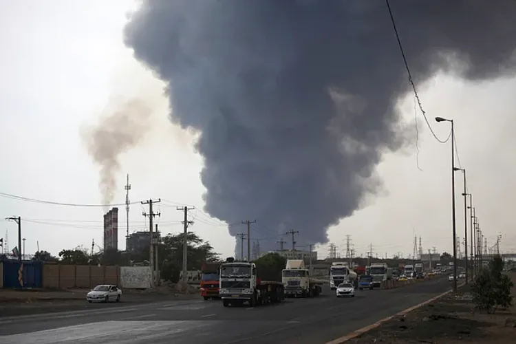 A black smoke rises in the sky as vehicles drive on the road after a massive explosion near the southern port city of Bandar Abbas, Iran, on April 26, 2025.