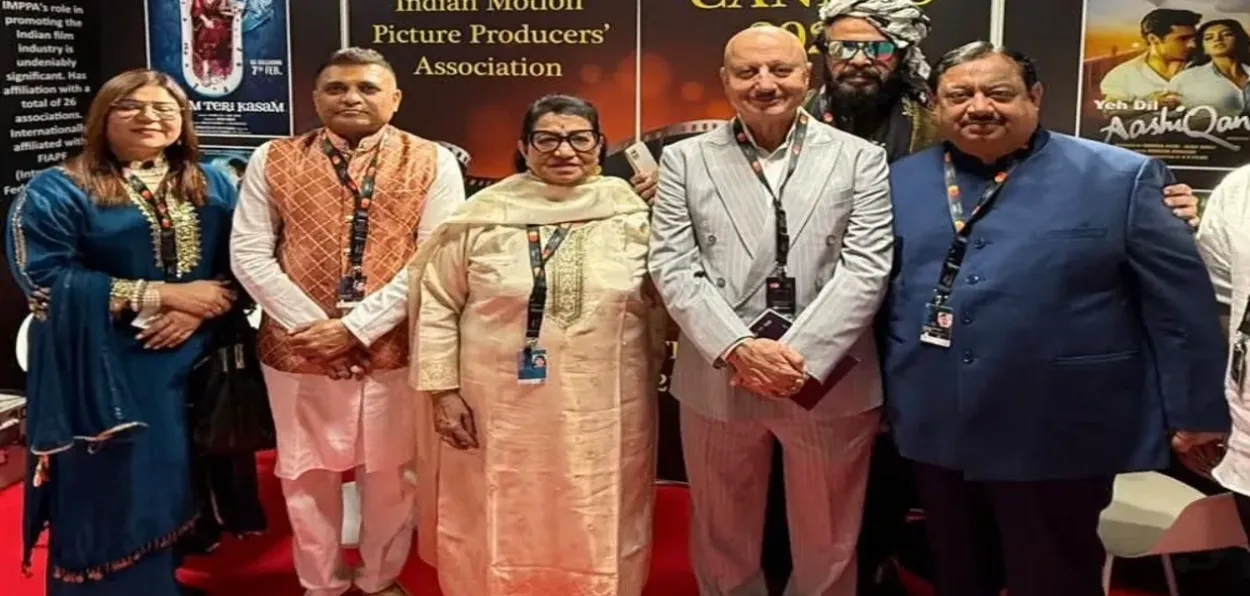 Anupam Kher inaugurating the IMPA outlet at the 78th Cannes Film Festival with Abhay Sinha (Right)