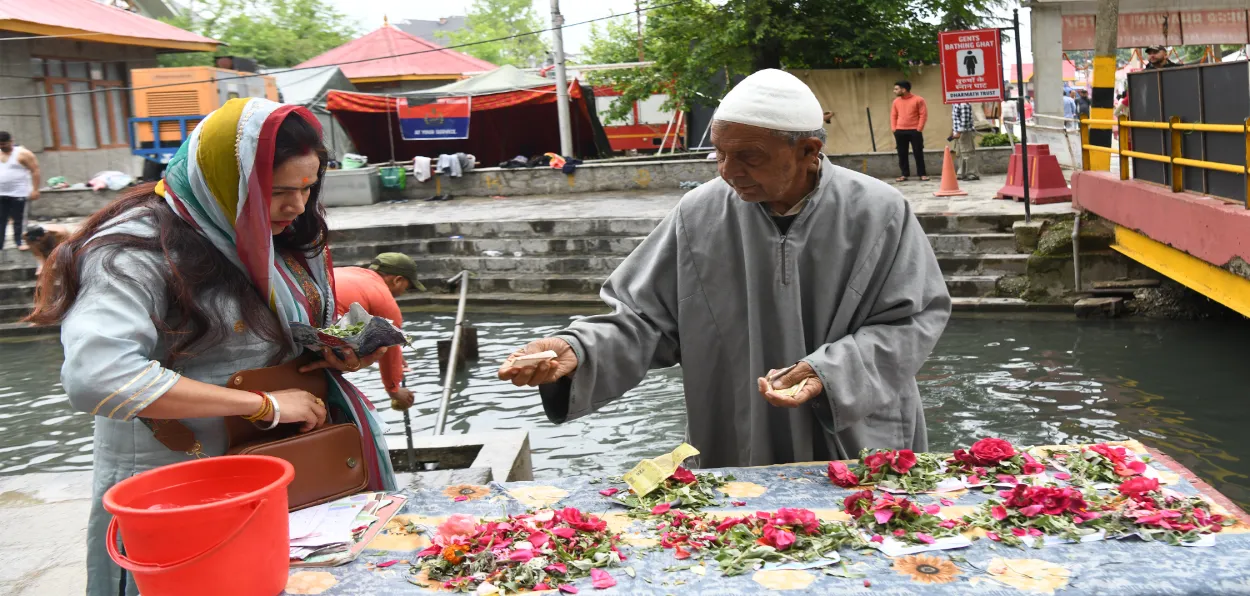 A Muslims selling flowers and wild mint to a Hindu devotee at Kheer Bhawani Mandir (Basit Zargar)