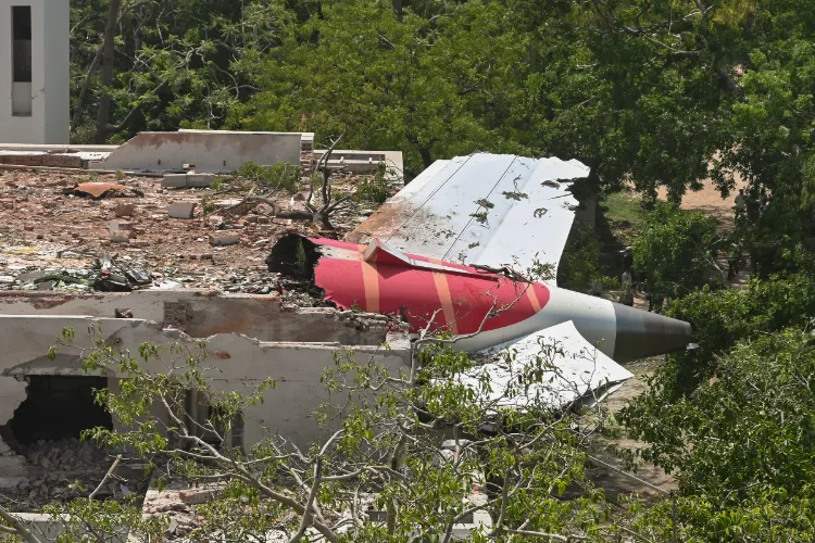A damaged part of the Air India plane that crashed moments after taking off from the airport, lies on a residential building in Ahmedabad