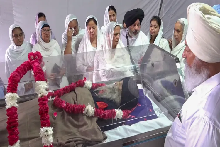 Family members and relatives pays their last respects to the mortal remains of marathoner Fauja Singh during his funeral, in Beas