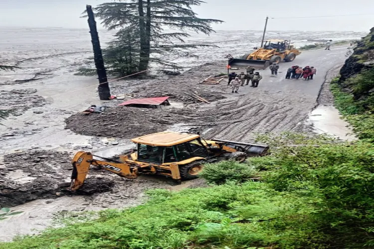 Indo-Tibetan Border Police (ITBP) team, with the help of JCB clears debris at a road near Dharali after a cloudburst and landslides hit at various places, in Uttarkashi