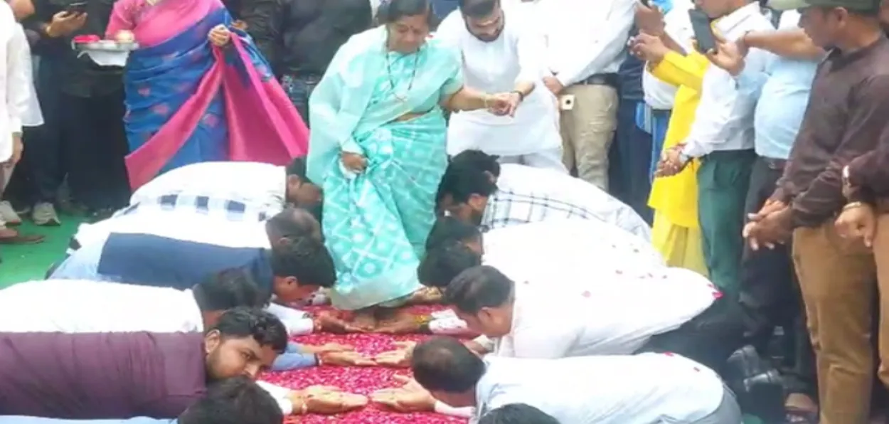 Martyr Gajendra Rao Surve's mother Kalpna Surve is made to walk over the flowers and hands of volunteers to her new house