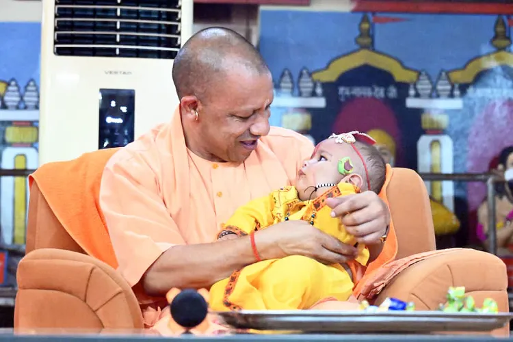 Uttar Pradesh Chief Minister Yogi Adityanath holding a child dressed as Krishna on Janmasthami