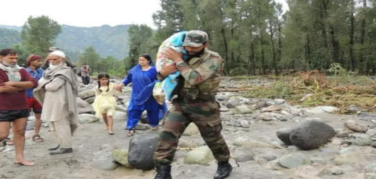 A soldiers with a child in the flood affected village