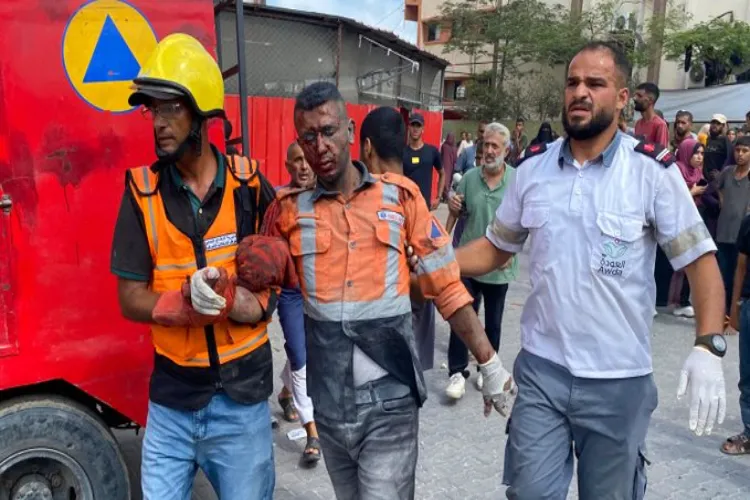 An injured rescue worker being taken out from bombed hospital in Gaza