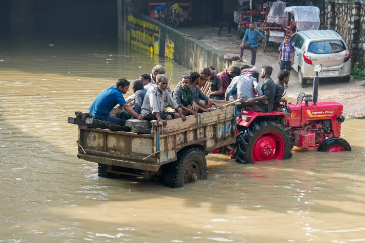 People take a tractor ride after the water from the raging Yamuna river flooded the area