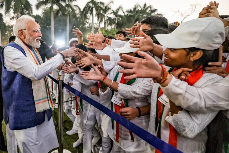Prime Minister Narendra Modi being greeted by children during a prayer meeting held on the birth anniversary of Mahatma Gandhi, at the Gandhi Smriti, in New Delhi.