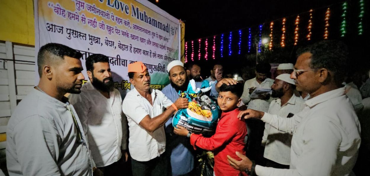 Volunteers handing over a relief package to a young boy in a relief camp 