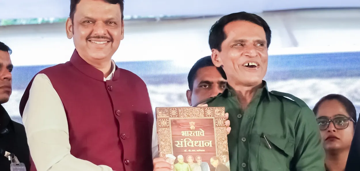  Maharashtra Chief Minister Devender  Fadnavis gifting a copy of the Constitution to Naxal commander Mallujula Venugopal Rao alias Sonu at his surrender ceremony at Gharchiroli