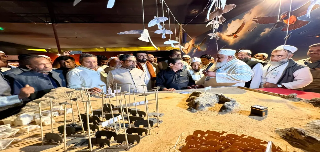 An organiser explain an exhibit to visitors at International Seerah exhibition