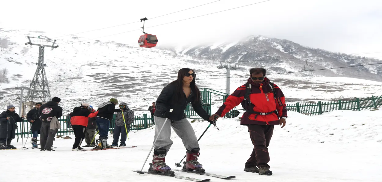 A tourist learning snowboarding in Gulmarg