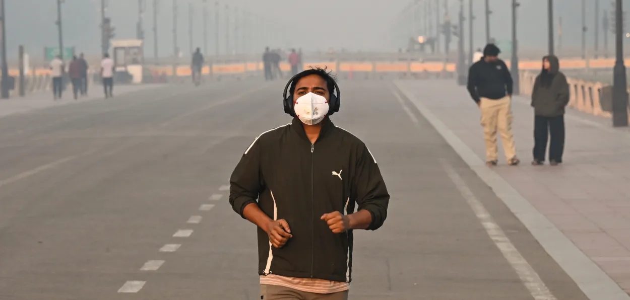 A man walking on Kartavya Path, New Delhi through a haze caused by air pollution