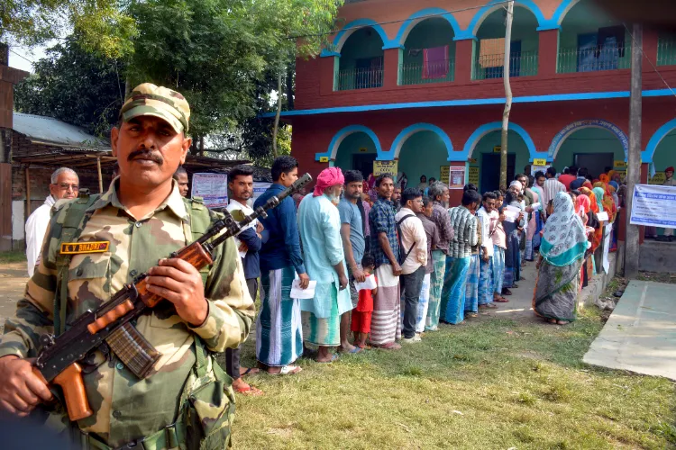 Voters wait in a queue to cast their votes at a polling booth during the second and final phase of the Bihar Assembly elections