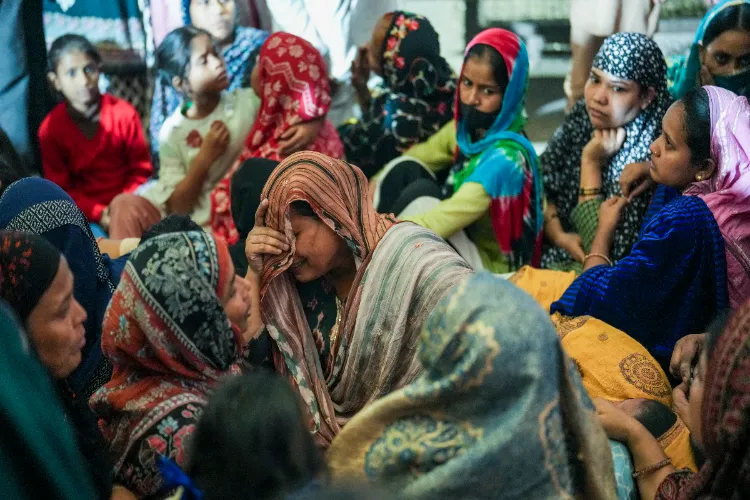 Family members and relatives of the e-rickshaw driver Jumman mourn after his mortal remains were brought to his residence