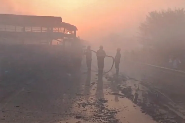 Firefighters extinguish a charred bus after a fog-hit pile-up involving buses and cars sparked fires on the Yamuna Expressway, in Mathura