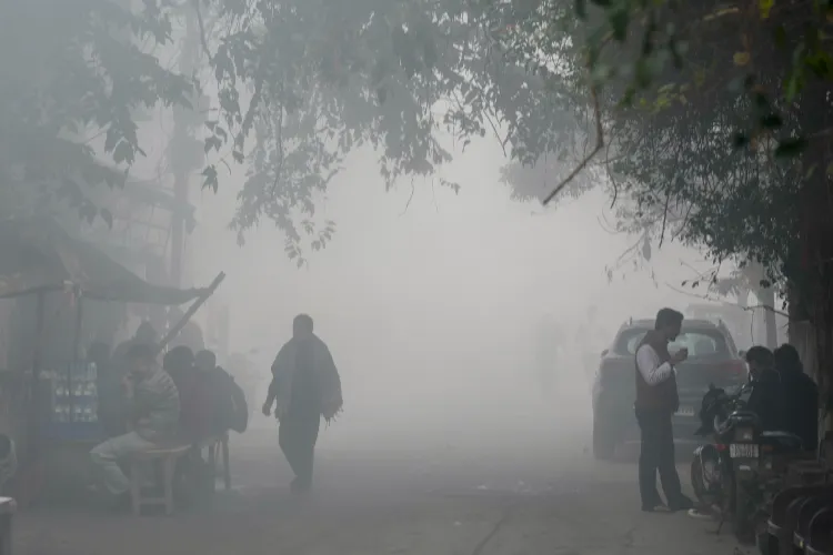  Commuters make their way amid low visibility due to a layer of smog, in New Delhi