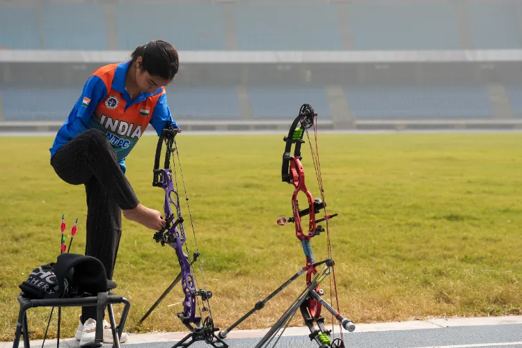 Paralympics medallist Sheetal Devi prepares her bow during a meeting with Australian Foreign Minister Penny Wong, unseen, at Jawaharlal Nehru Stadium in New Delhi