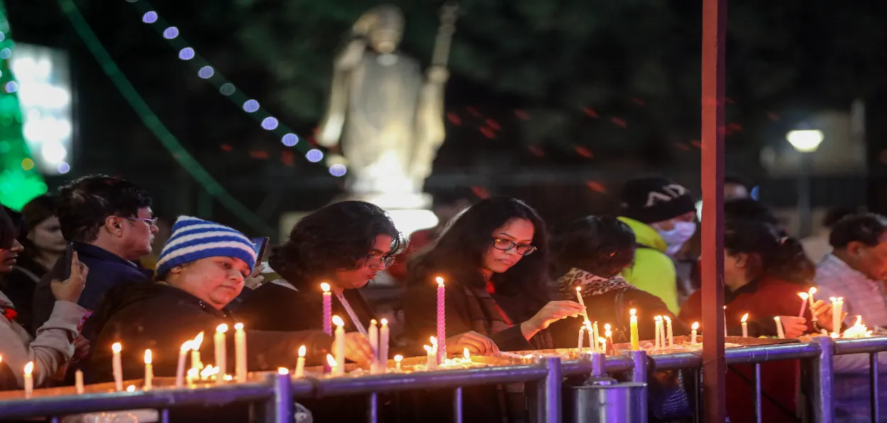 People lighting candles at the Sacred Heart Cathedral in New Delhi on Christmas eve