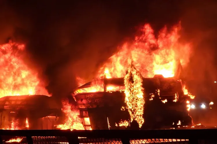Flames and smoke billow out after a bus caught fire following a collision with a speeding truck, in Chitradurga