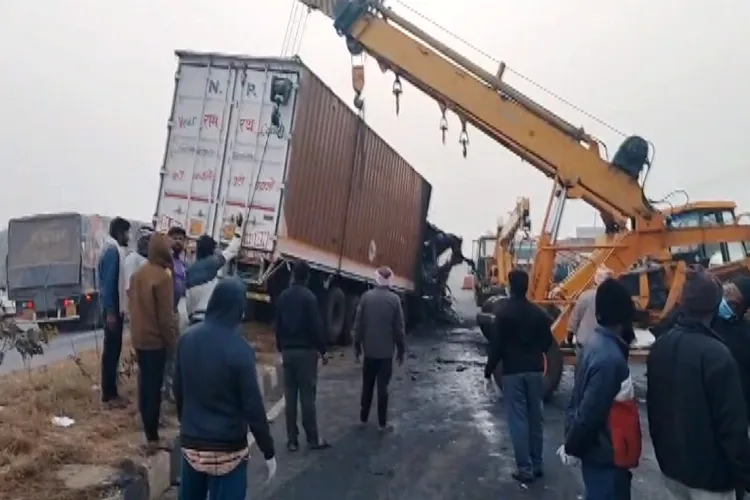 People gather after a speeding truck crashed against a luxury sleeper bus, which caught fire under the impact, in Chitradurga,