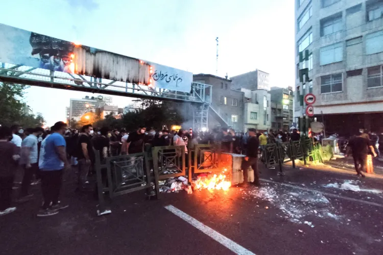 Protestors gather on the street in Iran as barricades burn during ongoing anti-government demonstrations, with security personnel deployed to control the situation