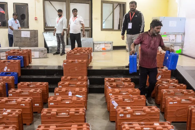 Polling officials collect EVMs and other election material at a distribution centre ahead of Brihanmumbai Municipal Corporation election, in Mumbai