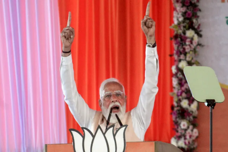 Prime Minister Narendra Modi addresses the gathering during a public meeting ahead of the Assembly elections, in Malda district, West Bengal
