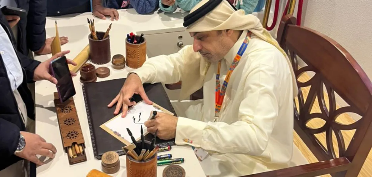 A Qatari calligrapher writing names for visitors in Arabic at the Delhi World Book Fair