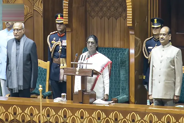 President Droupadi Murmu, Vice President Radhakrishnan and LS Speaker OM Birla stands for the national anthem before her address during the joint sitting of both Houses of Parliament on the first day of the Budget session, in New Delhi
