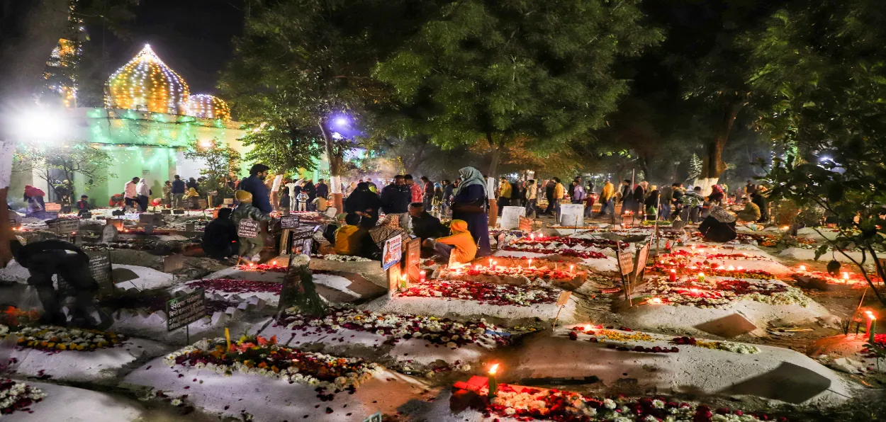 People lighting candles at the graves of their ancestors on Shab-e-barat