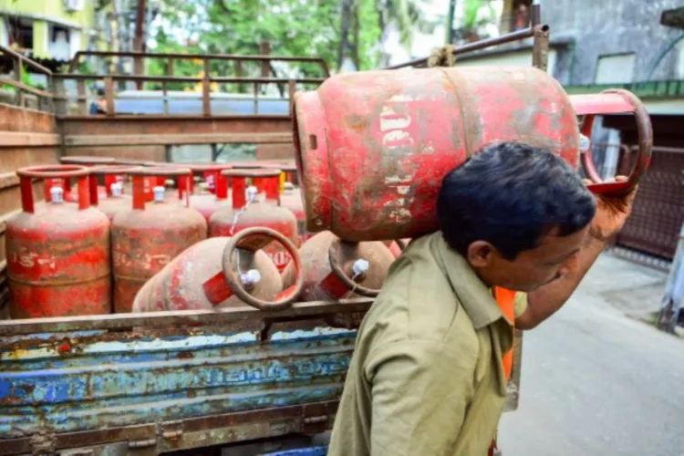 A worker carries a LPG cylinder