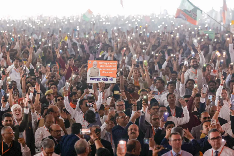 People hold a placard of Prime Minister Narendra Modi and light up mobile phone torches during inauguration of the newly constructed Noida International Airport, in Noida, Uttar Pradesh.
