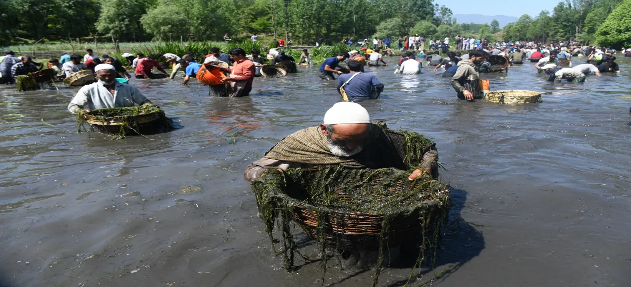 Villagers cleaning and fishing in the Panzath Naag as p[art of their annual festival