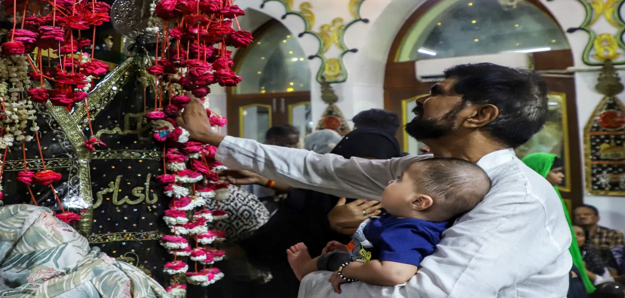A father with his child offers prayers on the 8th day of Muharram at Dariya Wali Masjid, Lucknow