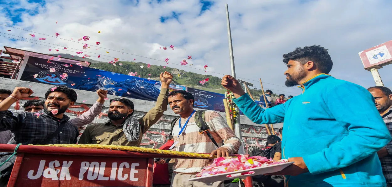 A Kashmiri man showering petals on pilgrims at Baltal, one of the base camps for Amarnath pilgrimage