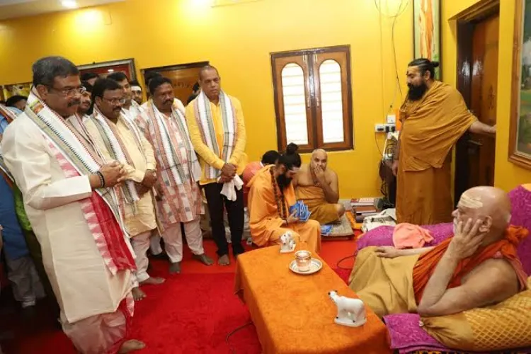 Union Education Minister Dharmendra Pradhan greets spiritual leader Swami Nischalananda Saraswati during a visit to the Govardhan Math on the occasion of the Rath Yatra festival, in Puri