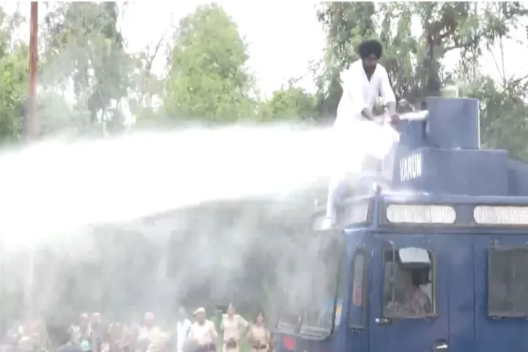 Akali Dal Waris Punjab De worker climbs over a water cannon vehicle during a protest