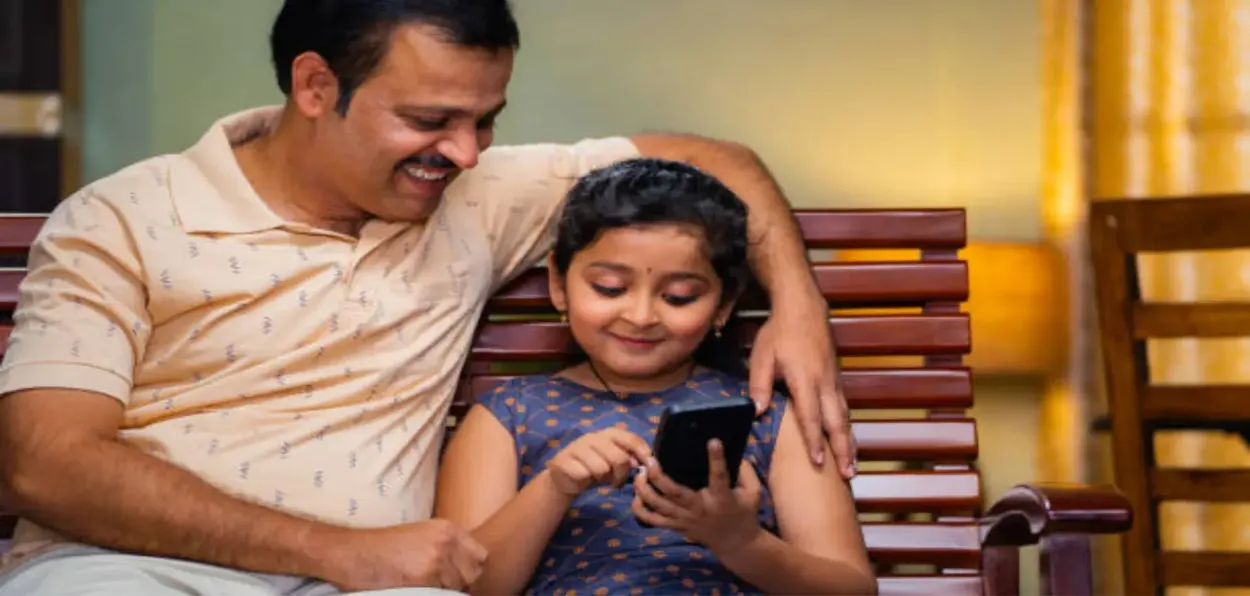A father and young daughter on mobile phone (Representational)