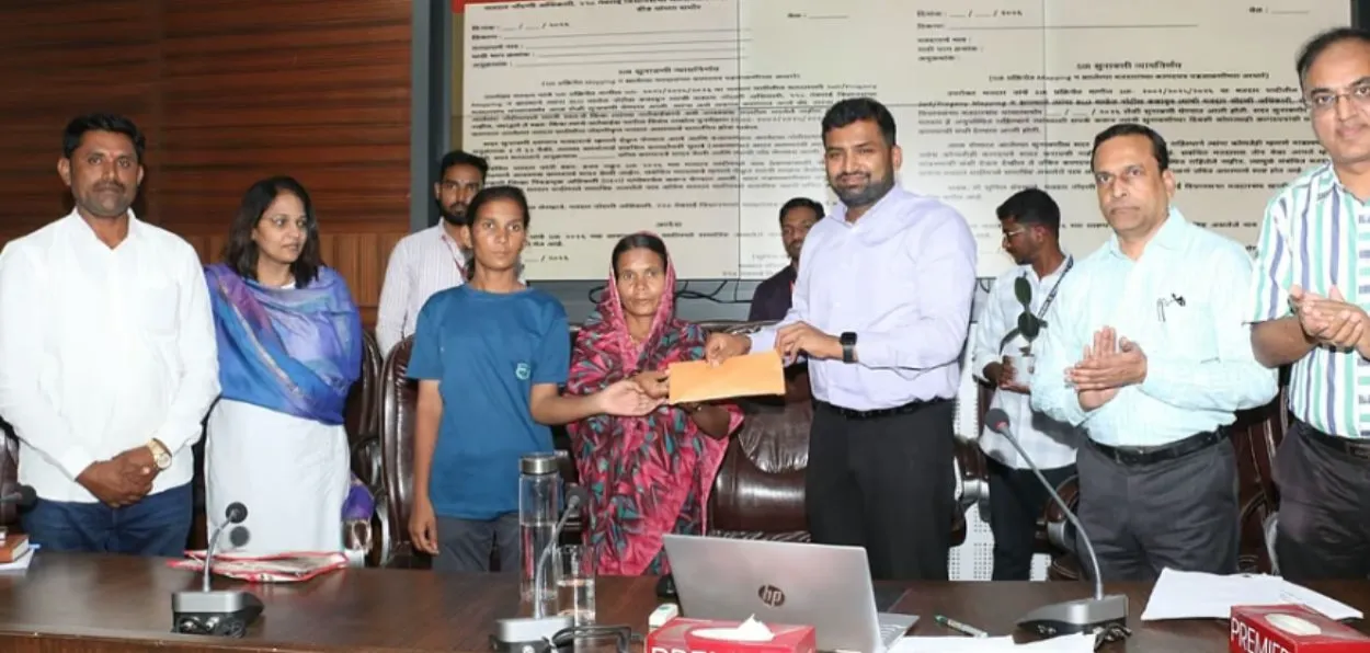 Ramabai receiving the cheque from Beed District Collector Vivek Johnson
