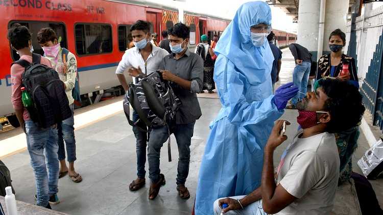 A health worker wearing a PPE kit conducts Antigen test for passengers at Dadar station (w) arriving from Gujarat, amid a surge in COVID-19 cases, in Mumbai on April 10