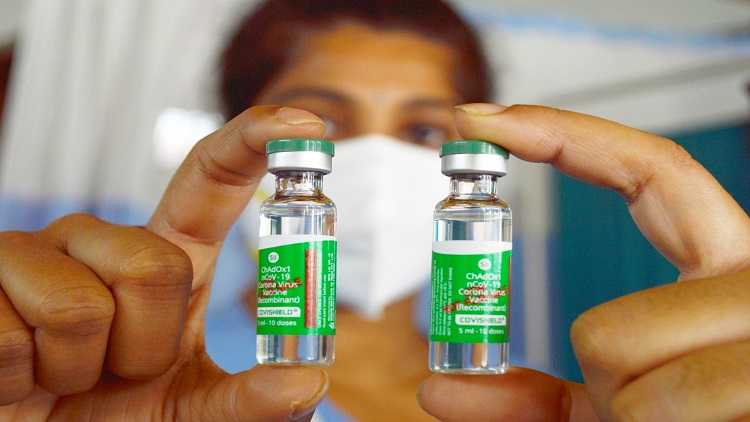 A nurse holds up COVID vaccine bottles in Bengaluru, India