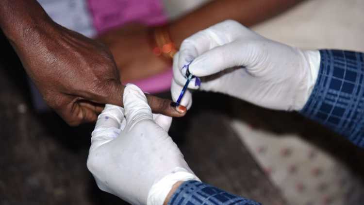 UP Panchayat polls: A poll official inking a man's finger to denote that he has cast his vote 