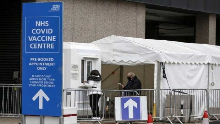 People are seen at an NHS COVID-19 vaccination center