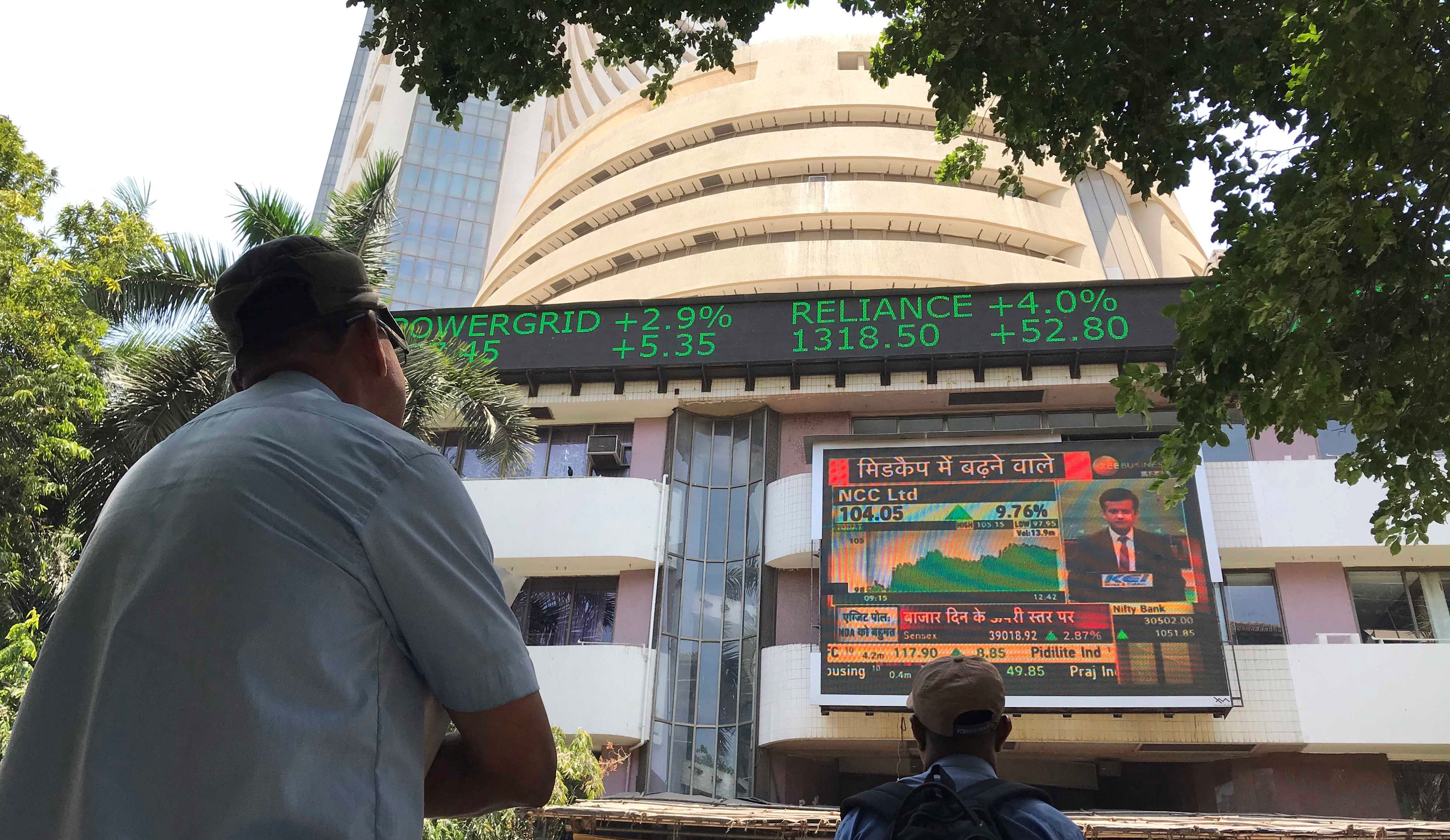 People watch the giant screen outside Bombay Stock Exchange in Mumbai