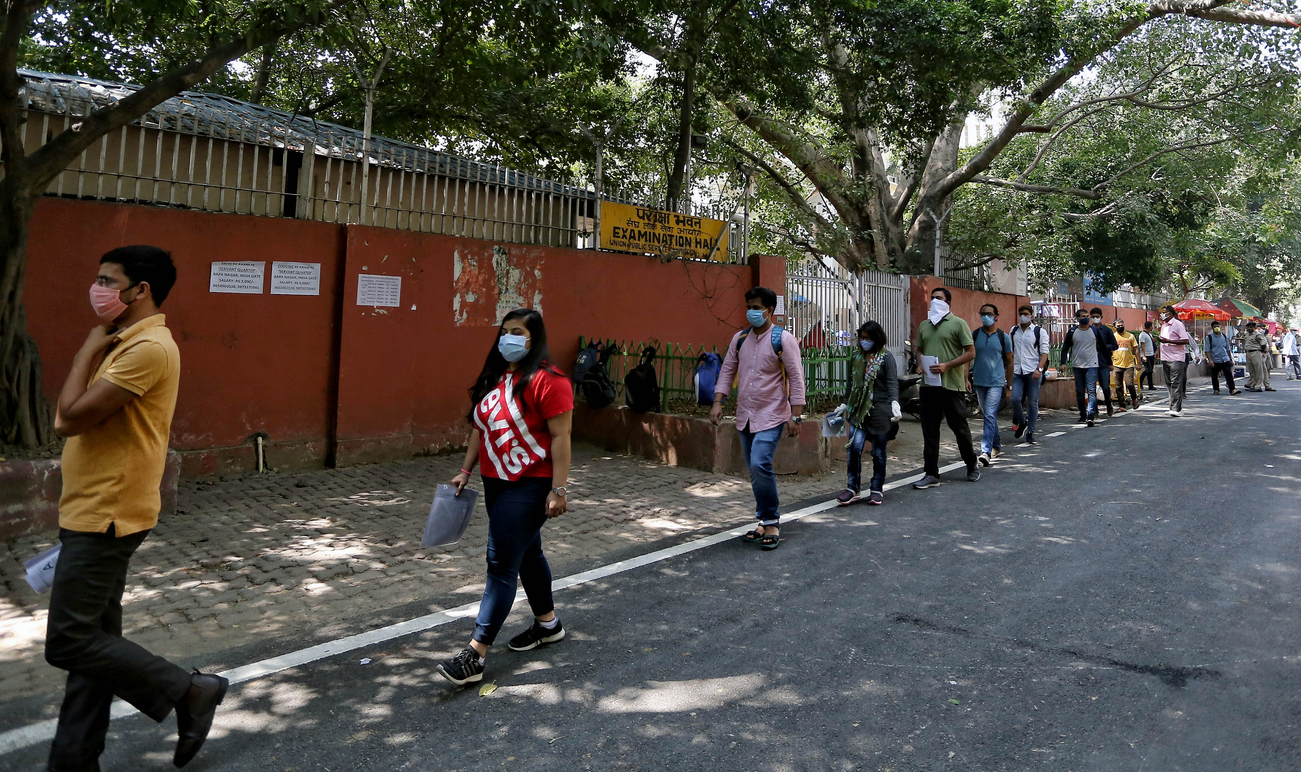Candidates stand in a queue as they appear in the Union Public Service Commission (UPSC) prelims exam 2020, in New Delhi