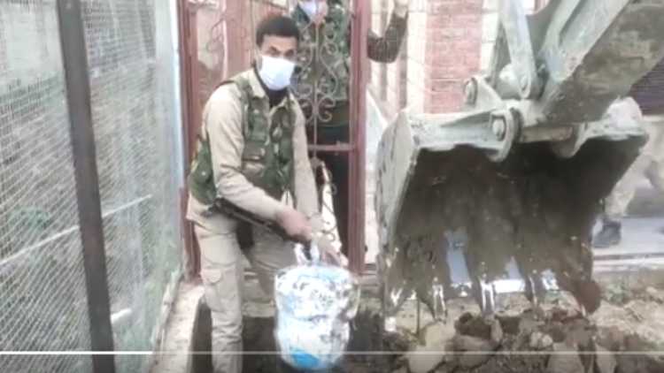 A policeman lifting Hashish packets from the excavation site (Twitter)